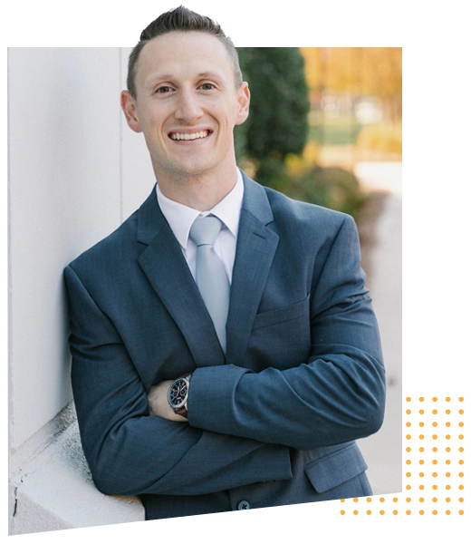 Dr. Jordan Barker smiling at camera while leaning against wall