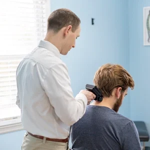 Chiropractor performing a handheld spinal scan